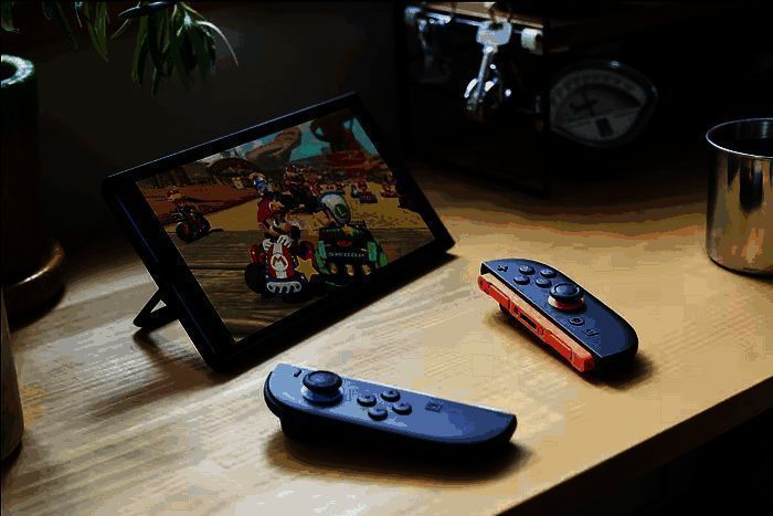 任天堂新主机Switch 2的实物展示图，主机放置于桌面，周围有手柄和充电器