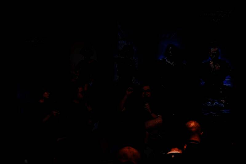 乔纳森・罗杰斯在活动现场与玩家交流，背景为流放之路2宣传海报