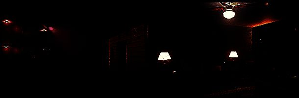 艾玛在旅馆房间中翻找线索，墙上挂着可疑的照片和笔记