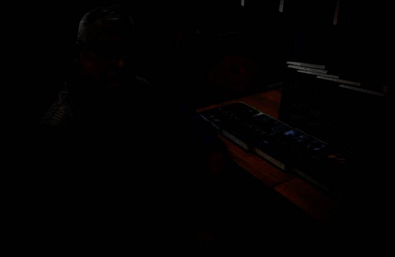 安杰伊·萨普科夫斯基接受采访现场照片，背景为《巫师》相关书籍封面展示