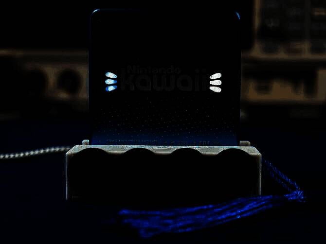 迷你版Wii主机正面展示，外形酷似一张卡片，颜色粉嫩可爱