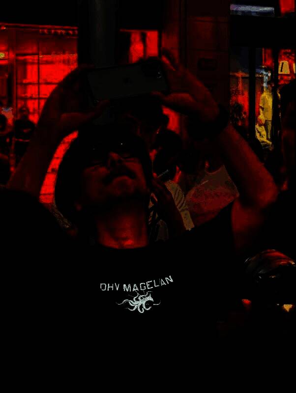 小岛秀夫在上海街头手持相机采风，身穿黑色外套