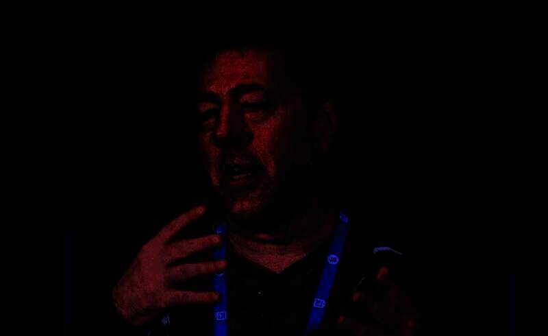 朱利安·勒菲早期工作照，专注设计游戏场景，桌上堆满设计草图与代码文档