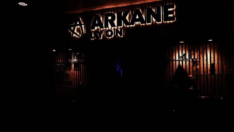 Arkane里昂工作室团队成员在电脑前进行设计与讨论，背景为《刀锋战士》项目概念图