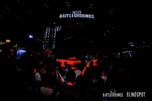 职业选手GODV身穿白色联名外套站在舞台中央，手持麦克风与观众互动