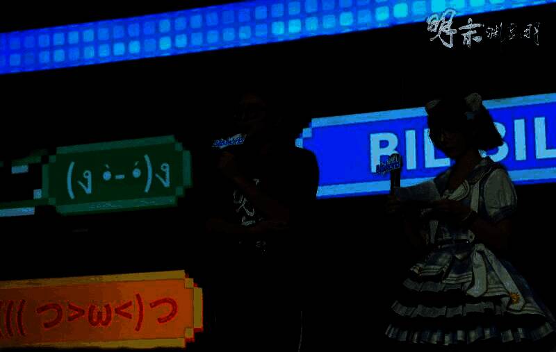 玩家正在试玩游戏，屏幕上显示BOSS战画面，周围聚集观众