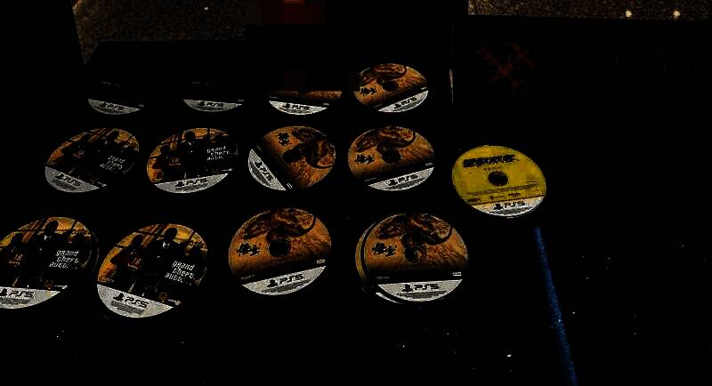 桌面上摆放着被查获的156张PS5游戏光盘，部分可见《黑神话：悟空》和《赛博朋克2077》封面