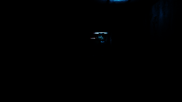 游戏中主角在昏暗病房内小心翼翼前进，手电筒光束扫过布满血迹的墙壁和翻倒的病床