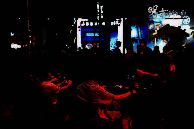 展台全景视角，玩家排队等待试玩《明末：渊虚之羽》，背景为巨大的游戏宣传海报，灯光氛围浓厚