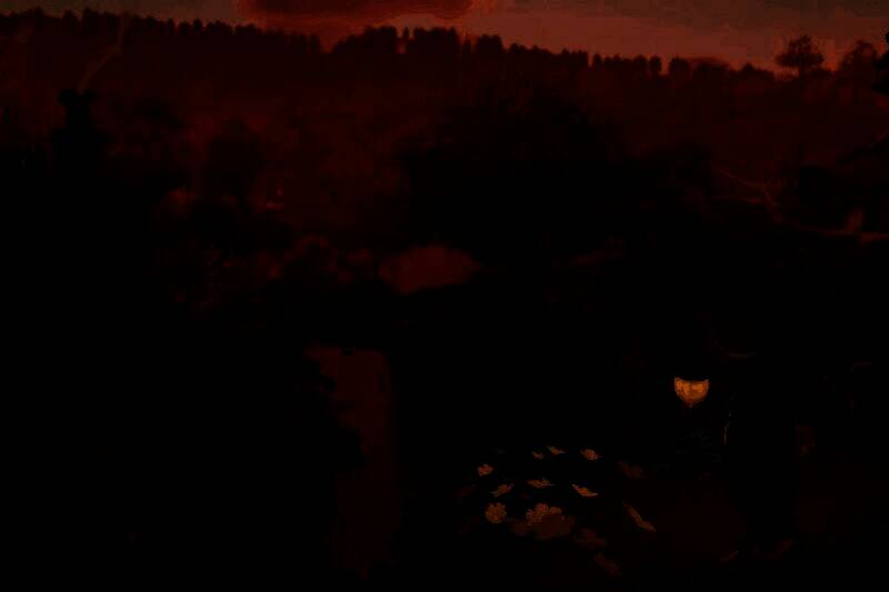 《指环王：夏尔传说》游戏画面展示霍比特人居住的温馨洞穴屋，周围绿意盎然，远处山丘起伏，充满田园诗意氛围