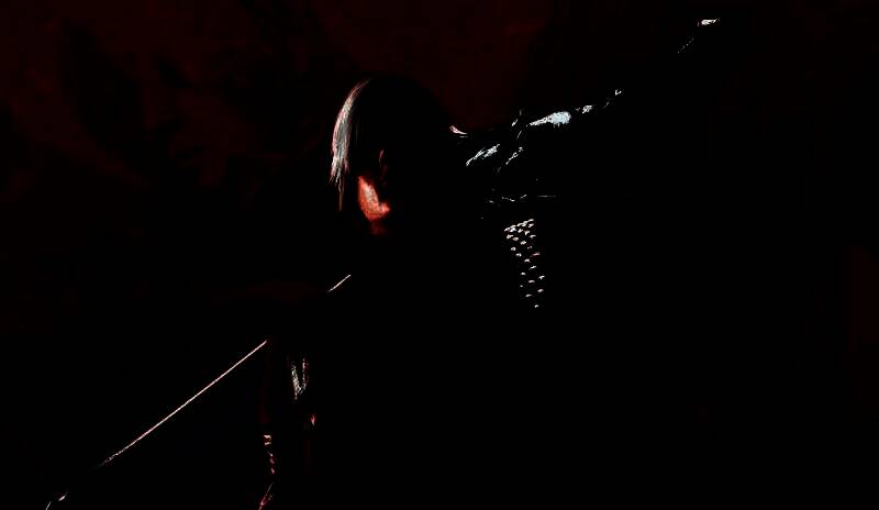 《鬼泣3》游戏画面，但丁在烈焰与魔物中挥舞双枪，战斗特效绚丽，场景充满哥特风格