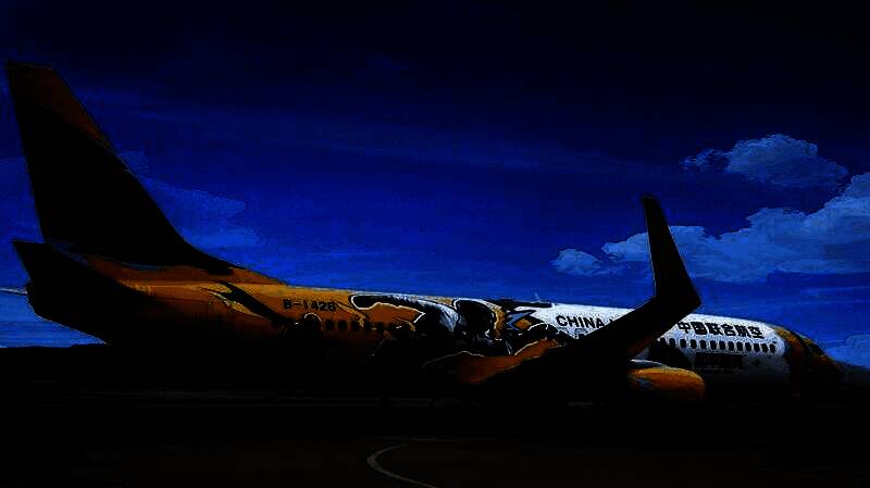 ‘和平精英号’彩绘飞机停靠在机场，机身涂装鲜明炫酷，融合游戏角色与游戏符号，整体视觉冲击力强