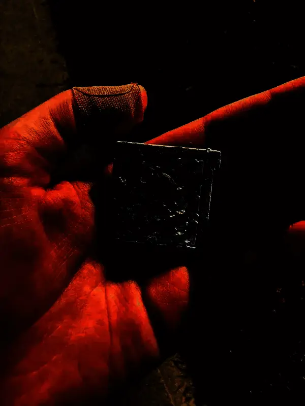 卡带侧面视角，显示严重挤压痕迹，塑料边缘翘起