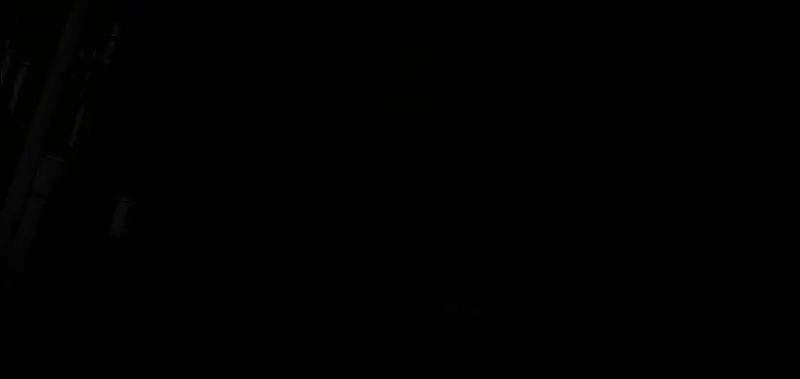 达米安版蝙蝠侠驾驶摩托飞跃杀手鳄的实机画面，场景为哥谭市废弃码头，夜色中火花四溅