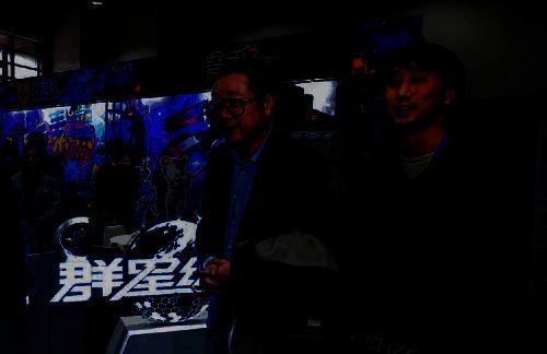 刘慈欣在《群星纪元》展台前与工作人员交流，神情专注