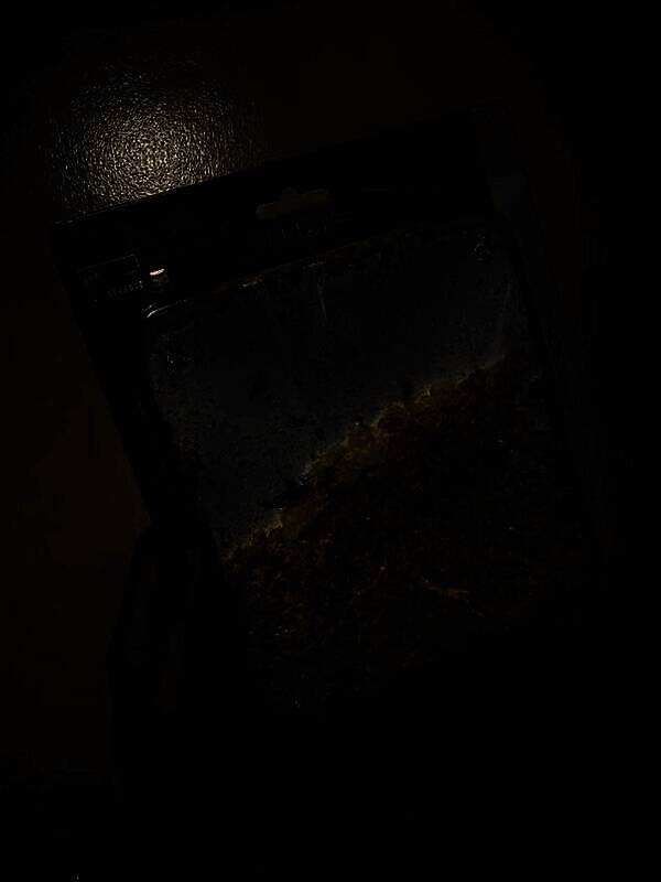 未拆封的3DS保护壳包装盒打开后内部充满彩色碎屑，塑料已完全降解成粉末状残渣