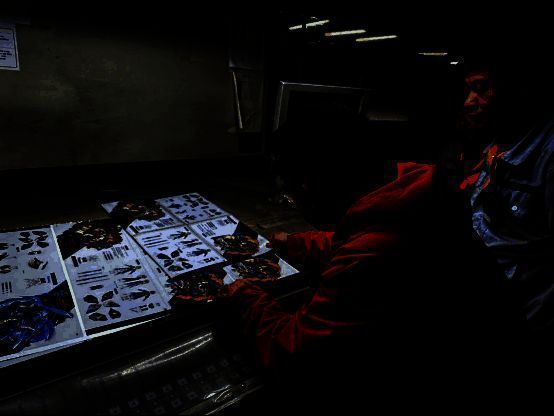 工作人员正在对《崩坏：星穹铁道》纪念画册进行现场色彩校准，确保每一页印刷效果精准还原原画质感