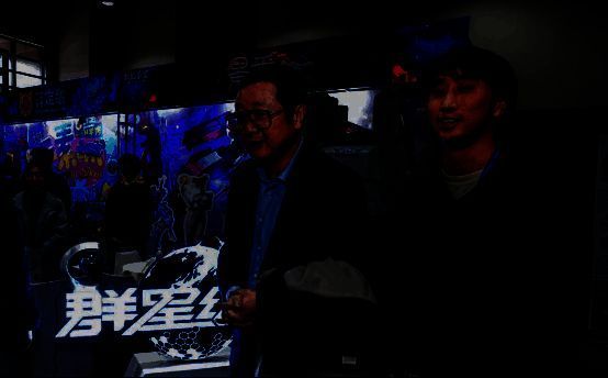 刘慈欣站在《群星纪元》展台前，认真观看游戏演示画面，神情专注