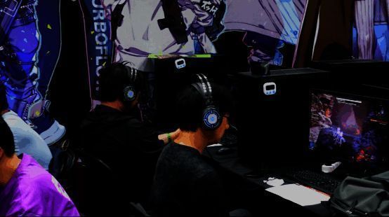 试玩玩家专注操作手柄，屏幕上机甲正与巨大BOSS展开空中对决，特效绚丽