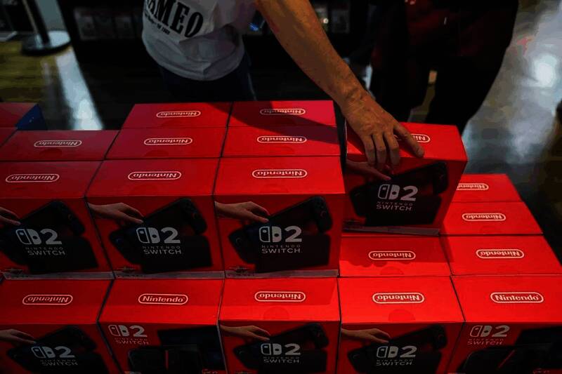 任天堂Switch2主机展示图，银色边框搭配OLED屏幕，放置在黑色背景上，周围环绕赛车与马里奥元素装饰