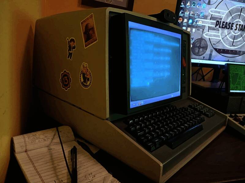 终端内部结构展示，可见现代主板与线缆整齐排布，屏幕显示《辐射》风格的操作界面