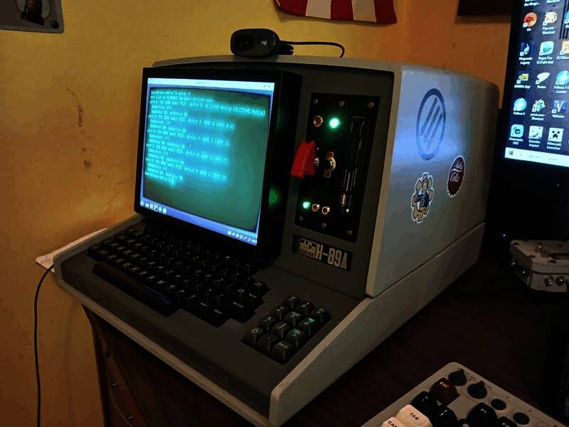 玩家在家中展示该终端设备，背景为《辐射》主题装饰，屏幕亮起绿色文字界面