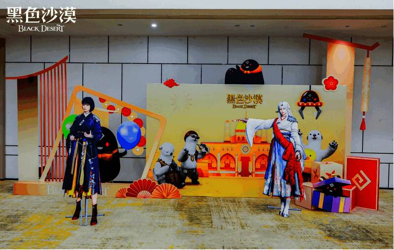 《黑色沙漠》线下活动全景图，玩家与开发团队围坐交流，现场氛围热烈，背景展示游戏LOGO与主题海报