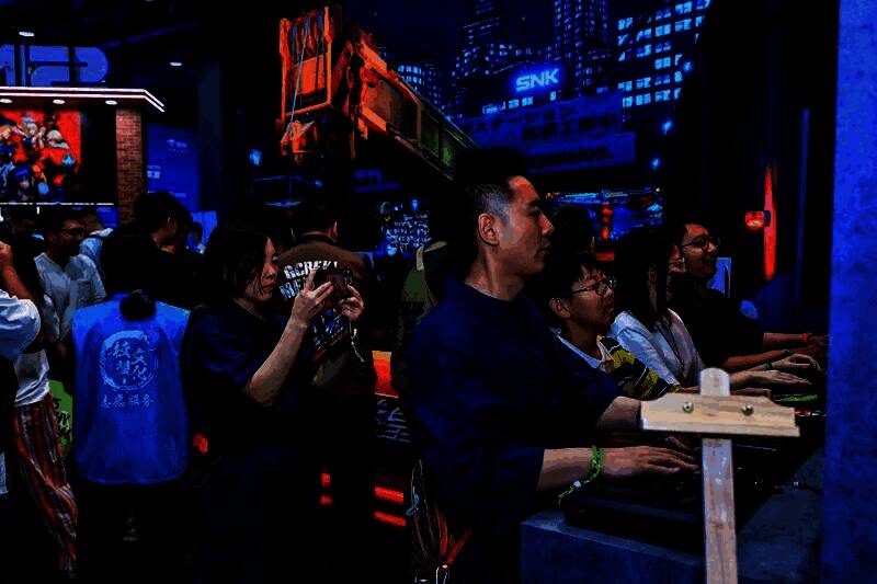 两位玩家在试玩区进行对战，周围观众围观