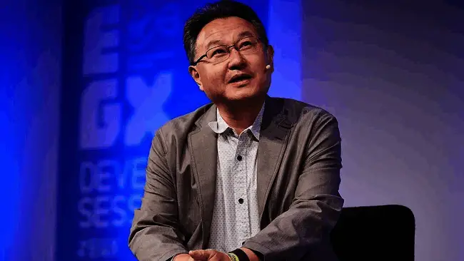 吉田修平在播客节目中谈论Switch 2日本特供版，神情专注，背景为游戏主机与标志