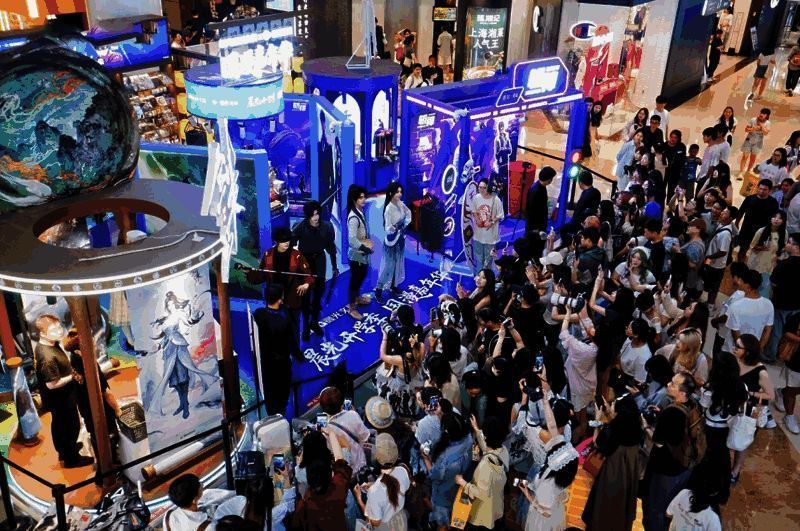 晨光国漫嘉年华活动现场全景，南京路宏伊广场被国漫元素装饰成一座“痛楼”，灯光璀璨，人潮涌动