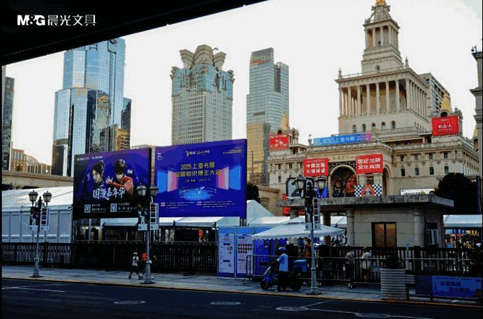 上海书展现场人潮涌动，晨光展台前年轻人排队打卡，充满国漫元素的背景墙吸引众多观众合影