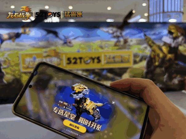 《龙石战争》游戏界面与《猛兽匣》机甲玩具并列展示，体现虚拟与实体的视觉融合