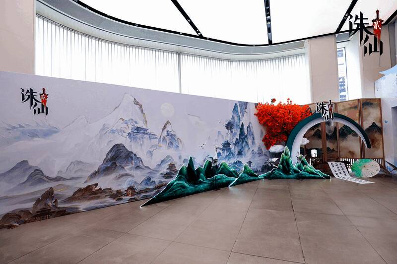 玩家在华为门店专注试玩《诛仙2》，屏幕上展现细腻的仙侠场景，周围展板展示游戏角色与世界观