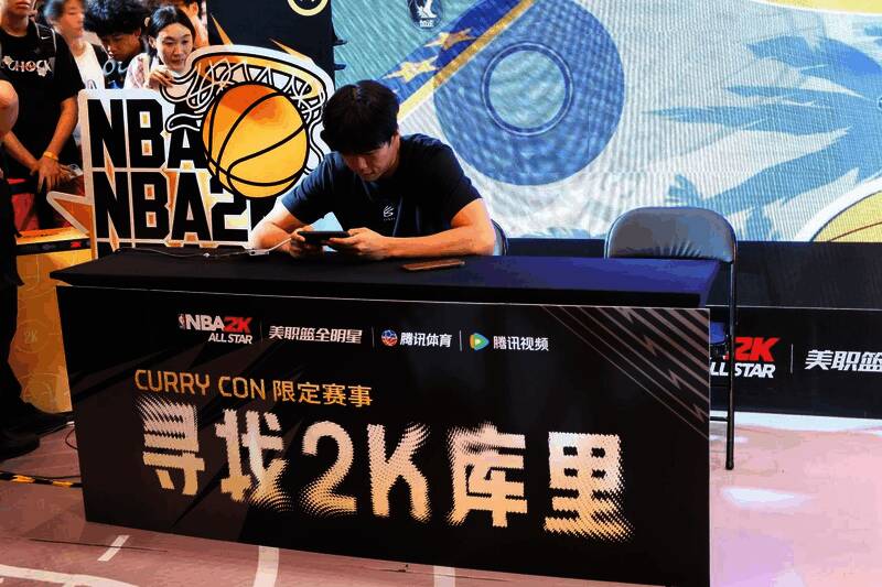 一位说唱艺人正在体验游戏，身旁有工作人员指导操作