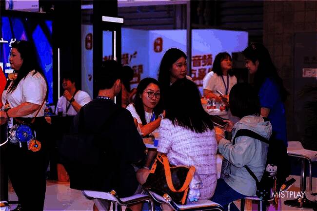 Mistplay在ChinaJoy展会上的展台现场，人头攒动，工作人员正与来访嘉宾交流