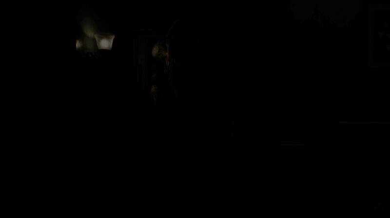 科隆游戏展现场玩家试玩《生化危机9》的场景，展台灯光昏暗，屏幕中呈现紧张恐怖的游戏画面