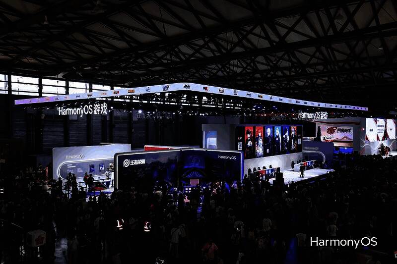 《少女前线2：追放》展台全景，1:1机甲模型矗立中央，灯光炫酷，玩家纷纷驻足拍照