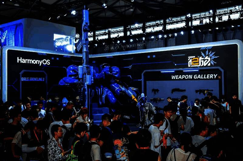 玩家与coser互动合影，背景为巨型机甲和霓虹灯效，现场氛围热烈