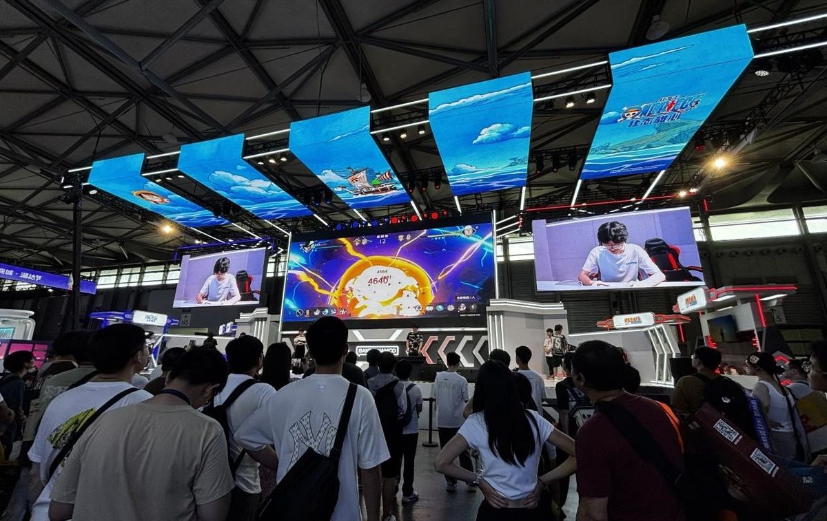 《航海王：壮志雄心》试玩区玩家专注操作，屏幕上呈现激烈战斗画面