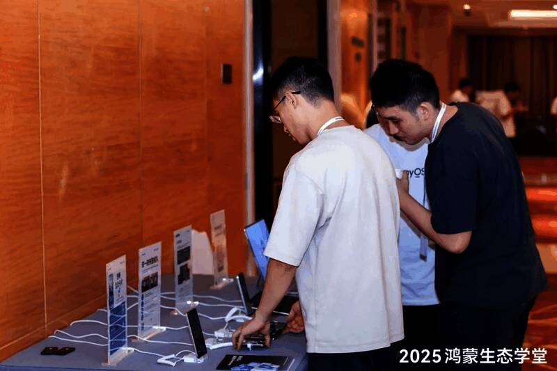 开发者在鸿蒙游戏体验区试玩支持无缝流转的多人对战游戏，现场互动热烈