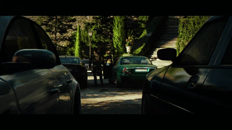 反派特工手持武器站在高处，俯视下方混乱场面