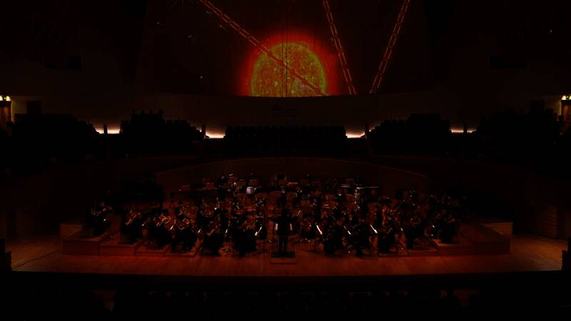 音乐会落幕，全体演奏者与工作人员登台谢幕，观众起立鼓掌，现场充满感动与掌声