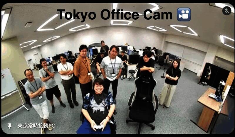 四叶草工作室成员围坐在一起玩游戏的温馨场景，大家紧盯屏幕，气氛专注而欢乐