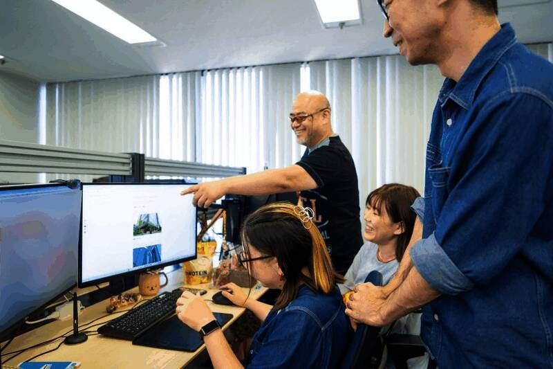 神谷英树与Clovers工作室团队合影，众人站在工作室标志前，神情自信