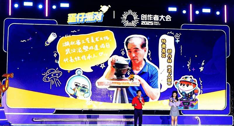 胡作林展示手工泥塑作品，身旁摆放着蛋仔形象的泥塑模型，极具创意融合感