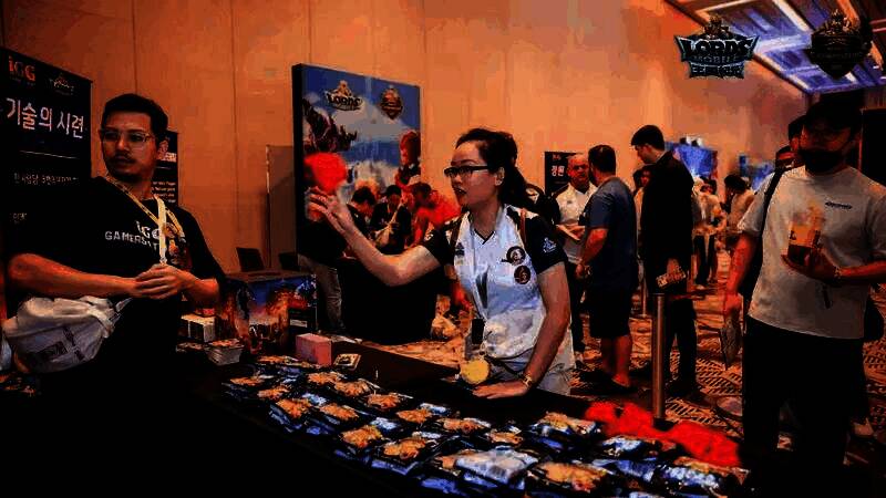 现场观众领取周边礼包，背景为游戏角色COSER合影区