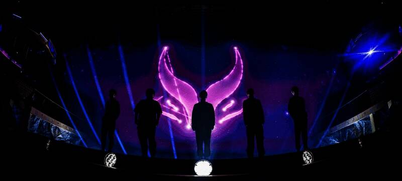 冠军队伍举起奖杯庆祝胜利，全场灯光聚焦舞台中央