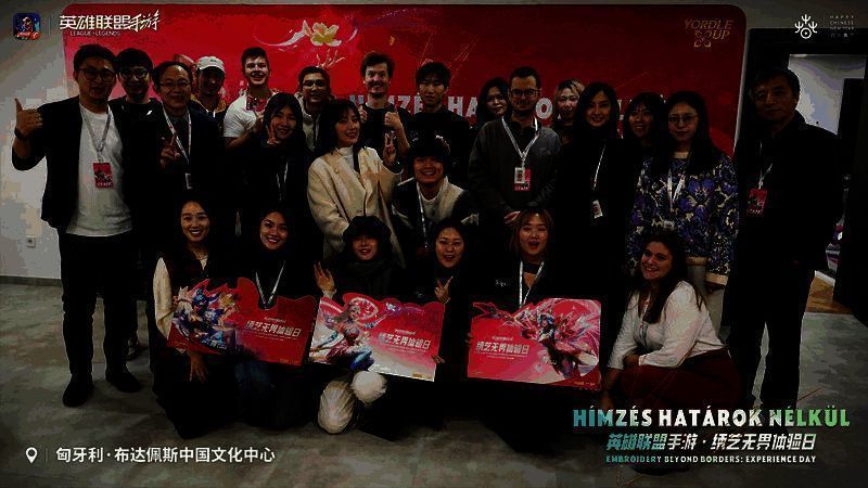 《英雄联盟手游》‘春展锦程’主题展区现场，巨幅苏绣作品悬挂中央，灯光下光泽流转，吸引众多观众驻足拍照