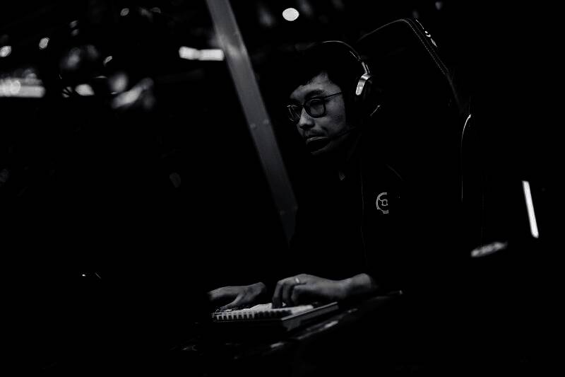 Nigma战队队员庆祝胜利，队员们击掌相庆，背景为TI14赛事主舞台灯光璀璨