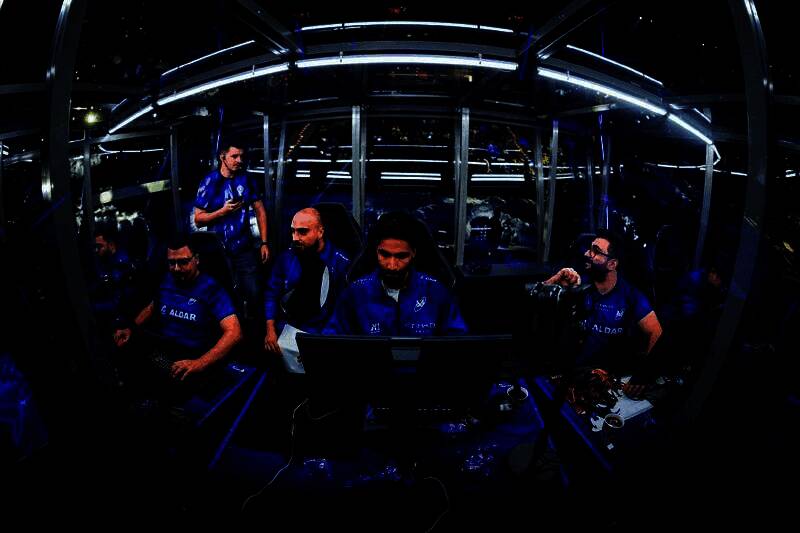 Tidebound战队成员神情落寞，低头离场，观众席灯光昏暗映衬出遗憾氛围